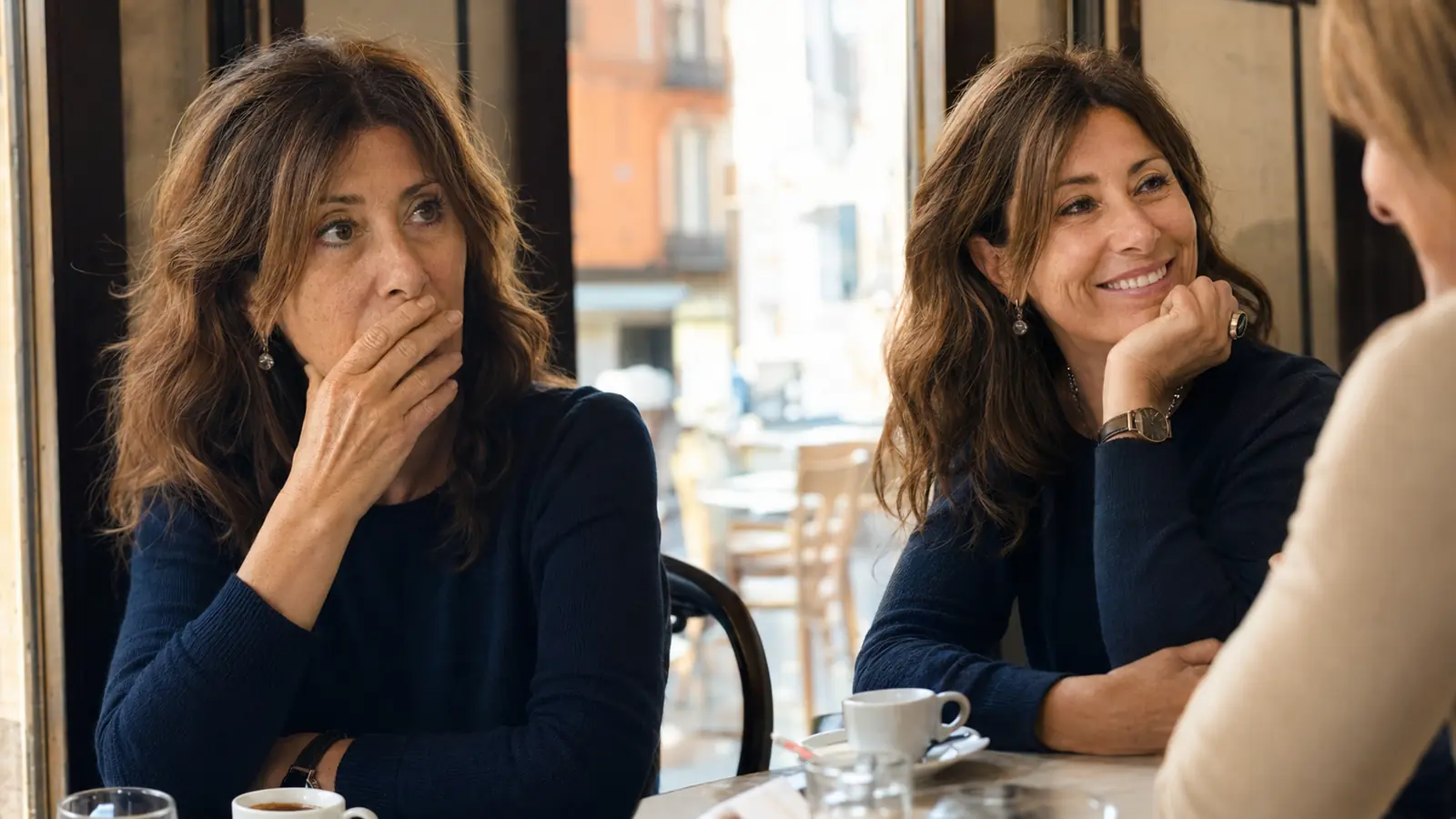Paola copre la bocca mentre conversa al bar
